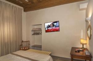 a room with a bed and a tv on the wall at Le Camere di Caterina in Lucca +38 photos
