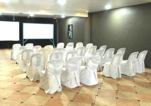 a room with white chairs and a projection screen at Altaroca Mountain Resort Antipolo in Antipolo