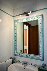 a bathroom with a mirror and a sink at Hotel Amyclae in Sperlonga