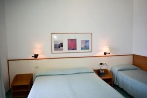 a bedroom with two beds and a picture on the wall at Hotel Amyclae in Sperlonga