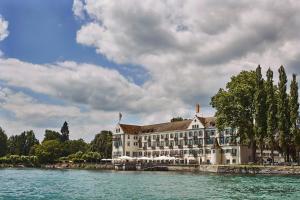 ein Gebäude auf dem Wasser vor einem See in der Unterkunft Steigenberger Inselhotel in Konstanz