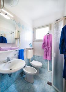 a bathroom with a sink and a toilet at Villaggio Michelangelo in Bibione
