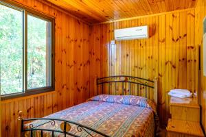 a bedroom with a bed in a wooden cabin at Platres Valley Houses in Platres