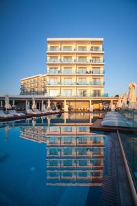 a hotel with a pool in front of a building at The Blue Ivy Hotel & Suites in Protaras