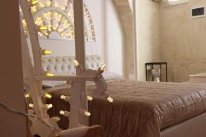 sypialnia z łóżkiem i krzesłem z oświetleniem w obiekcie Le LUMINARIe Sassi w mieście Matera