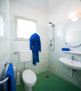 bagno con servizi igienici, lavandino e specchio di Villaggio Michelangelo a Bibione