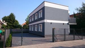 um edifício com uma cerca em frente em Apartamenty Między Jeziorami em Olsztyn