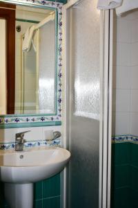 a bathroom with a sink and a mirror and a shower at Hotel Amyclae in Sperlonga