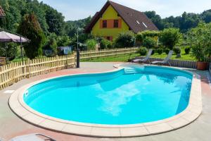 a swimming pool with a house in the background at Gästehaus Nora in Stein bei Loipersdof