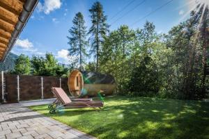 podwórko z krzesłem i domek na drzewie w obiekcie Viktoria Lodges w mieście Bach