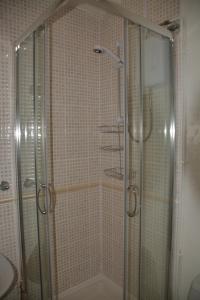 y baño con ducha y puerta de cristal. en St Marguerite, en Paignton