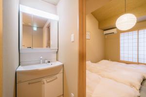 a bathroom with a sink and a bed and a mirror at Miro Sanjo Saiin Tei in Kyoto
