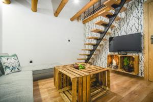 een woonkamer met open haard en tv bij Domki na Łazach in Uherce Mineralne