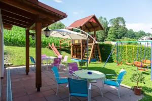 um pátio com mesas e cadeiras e um parque infantil em Gästehaus Nora em Stein