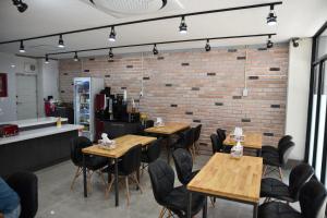 un restaurante con mesas y sillas de madera y una pared de ladrillo en Business Hotel Busan Station, en Busan