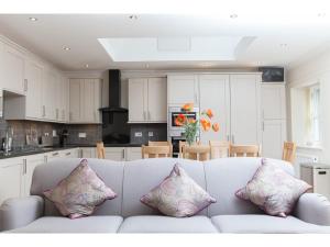 um sofá branco numa cozinha com almofadas em Historic Stone Built 4BR Cottage for 8 W/Parking em Edimburgo