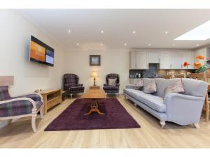 uma sala de estar com um sofá e uma mesa em Historic Stone Built 4BR Cottage for 8 W/Parking em Edimburgo