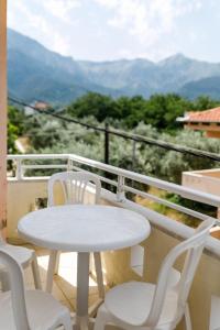 スカラ・ポタミアスにあるVilla Polinaの白いテーブルと椅子、景色を望むバルコニー