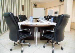 a conference room with a wooden table and black chairs at Hotel Bon Voyage in Lagos