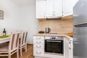 a kitchen with white cabinets and a stove top oven at Apartment Little Paradise - In the city center in Tivat +20 photos