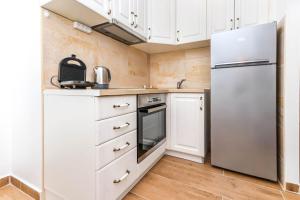 a kitchen with white cabinets and a refrigerator at Apartment Little Paradise - In the city center in Tivat