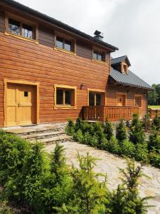 una gran casa de madera con un patio delante en Pod Miloňovou en Velké Karlovice