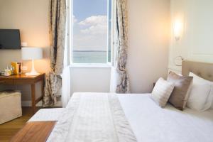 a bedroom with a bed and a window with the ocean at Grand Hotel Terme Sirmione in Sirmione