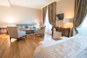a hotel room with a bed and a couch at Grand Hotel Terme Sirmione in Sirmione