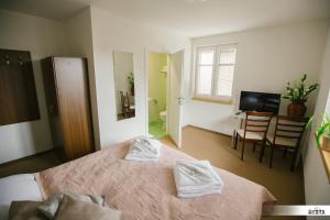 a bedroom with a bed with two white towels on it at Villa Šimák in Staré Splavy