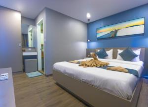 a bedroom with a large bed with a blue wall at Sara Resort in Koh Rong Sanloem
