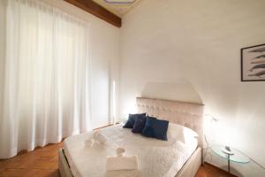 a bedroom with a large white bed with blue pillows at Apo2 Deluxe 2bdr family apartment by Ponte Vecchio in Florence