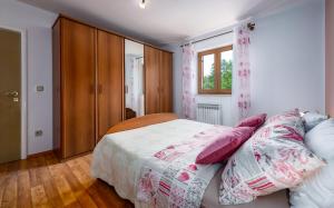 a bedroom with a bed with pink pillows on it at Villa Križanci in Žminj +26 photos