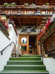 eine Treppe, die zu einem Gebäude mit Blumen führt in der Unterkunft Gasthof Geierwallihof in Vent