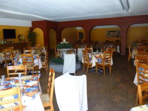 a dining room filled with tables and chairs at Hotel Hacienda in Oaxaca City