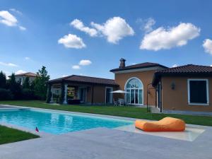 una casa con piscina di fronte a una casa di Front Row Golf Villa Bogogno a Bogogno
