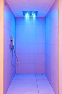 um quarto com um chuveiro com paredes azuis e brancas em Swiss-Chalet Merlischachen - Historik Chalet-Hotel Lodge em Küssnacht