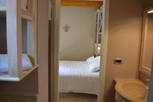 a bathroom with a bedroom with a bed and a sink at Hotel Danila in Portoferraio