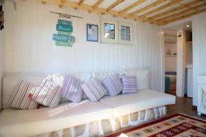 a white couch with purple pillows in a living room at Byblos Fishing Club Guesthouse in Jbeil