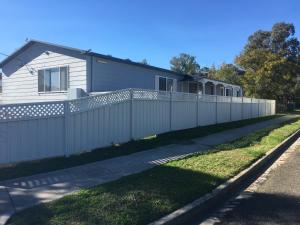 une clôture blanche devant une maison dans l'établissement Green Meadow, à Nowra