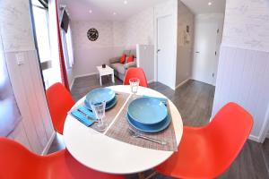 uma sala de jantar com uma mesa branca e cadeiras vermelhas em Apartamento Zenbeach 2ºA em Torremolinos