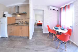 トレモリノスにあるApartamento Zenbeach 2ºAの赤い椅子とテーブル付きのキッチンが備わります。