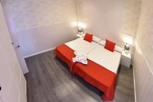 um quarto com uma cama grande e almofadas vermelhas e brancas em Apartamento Zenbeach 2ºA em Torremolinos