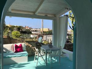 a porch with a table and a couch at Borgo Acqua in Lampedusa