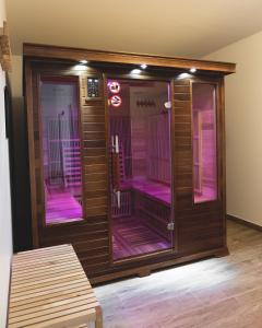 阿克斯萊泰爾姆的住宿－Au chalet des quatre saisons，一间设有粉红色灯的桑拿浴室的房间