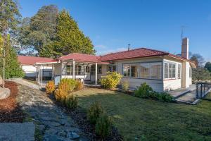 a white house with a red roof and a yard at Tarraleah Estate in Tarraleah