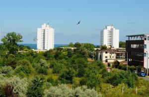 two tall white buildings in a city with trees at Vila La Matache in Eforie Nord