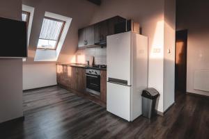 a kitchen with a white refrigerator and wooden floors at Villa u Arény in Ostrava