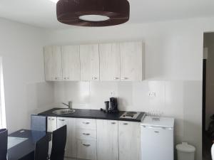 a kitchen with white cabinets and a black counter top at Apartment Djordje Budva-Jaz in Kukaljevina +11 photos