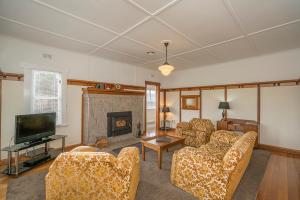 a living room with couches and a tv and a fireplace at Tarraleah Estate in Tarraleah