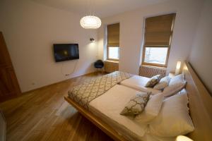 a bedroom with a large bed and a tv at President Apartment in Sarajevo